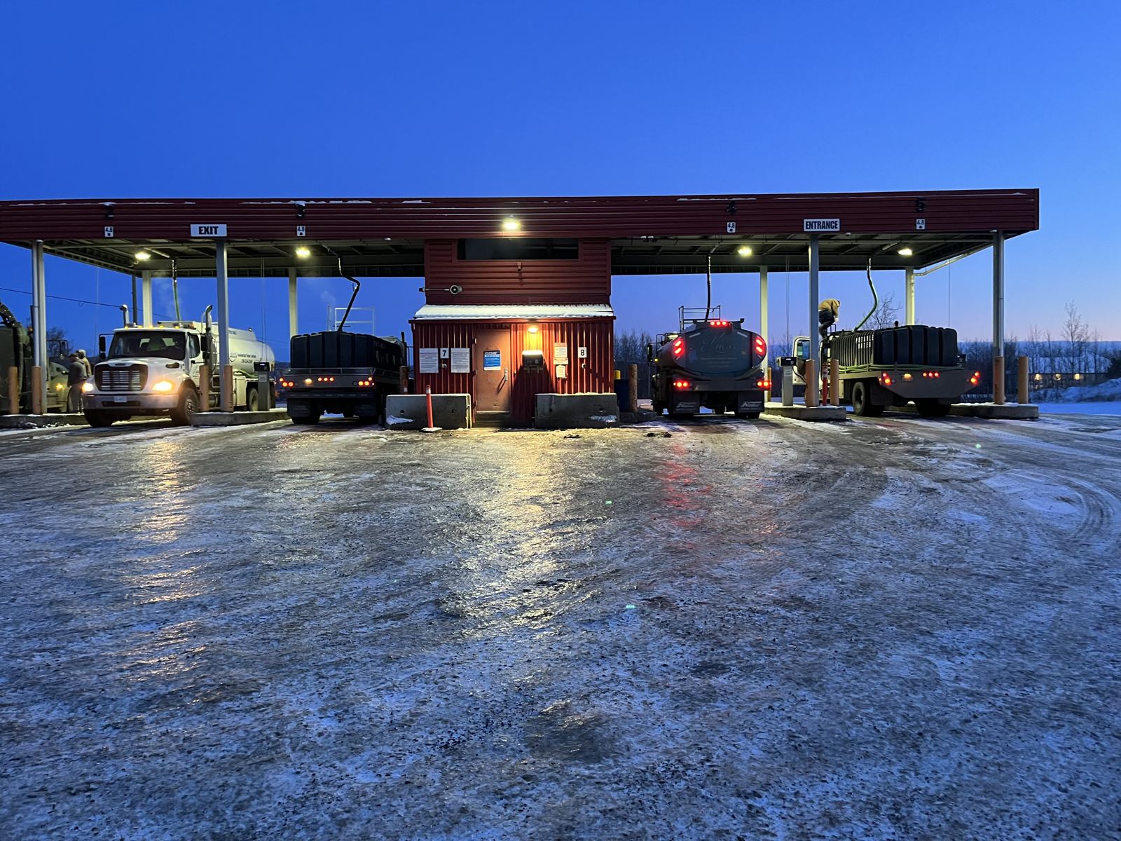 Lucas Water trucks filling at a bulk water station at dusk